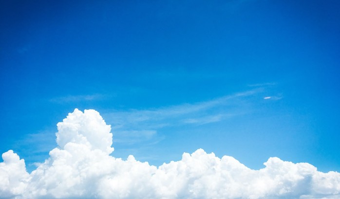 A plain blue sky with a white cloud.