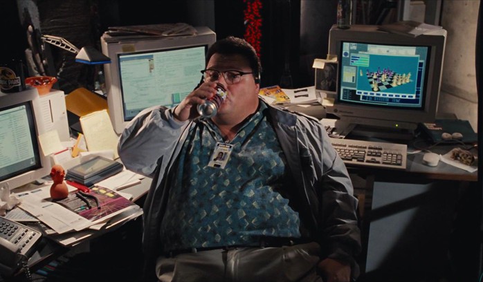 Dennis Nedry in Jurassic Park vibing, drinking a soda, in front of computers.